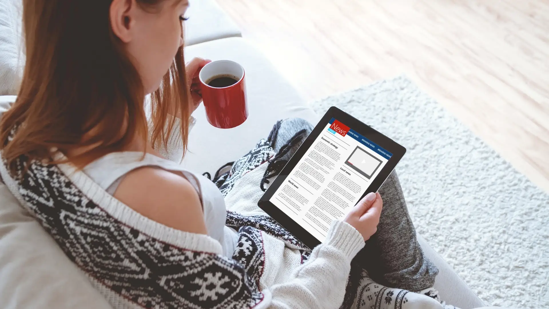 Woman reading the news on her tablet device Woman reading the news on her tablet device